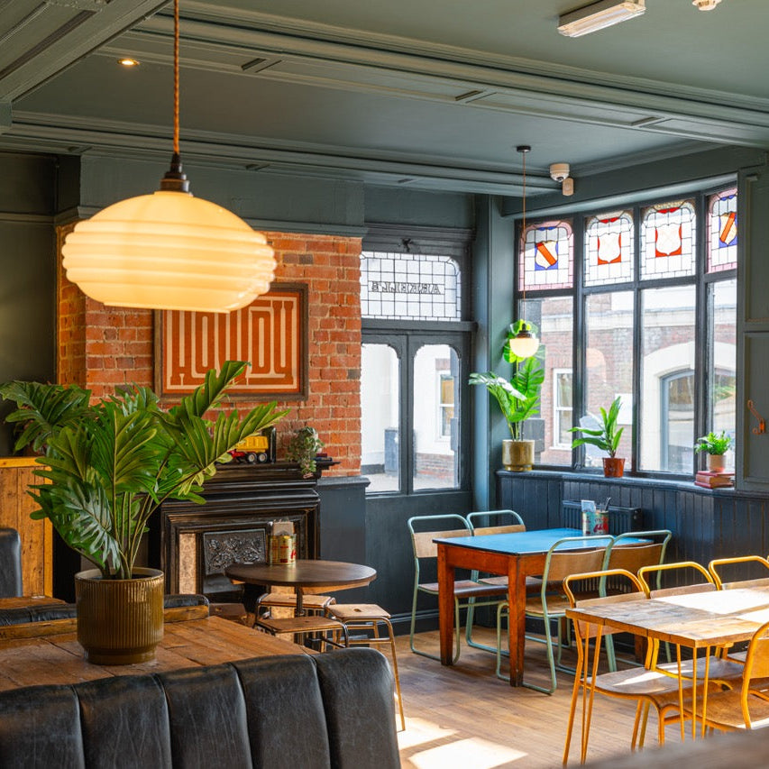 Window seating at The High Horse with plants and a brick fireplace wall