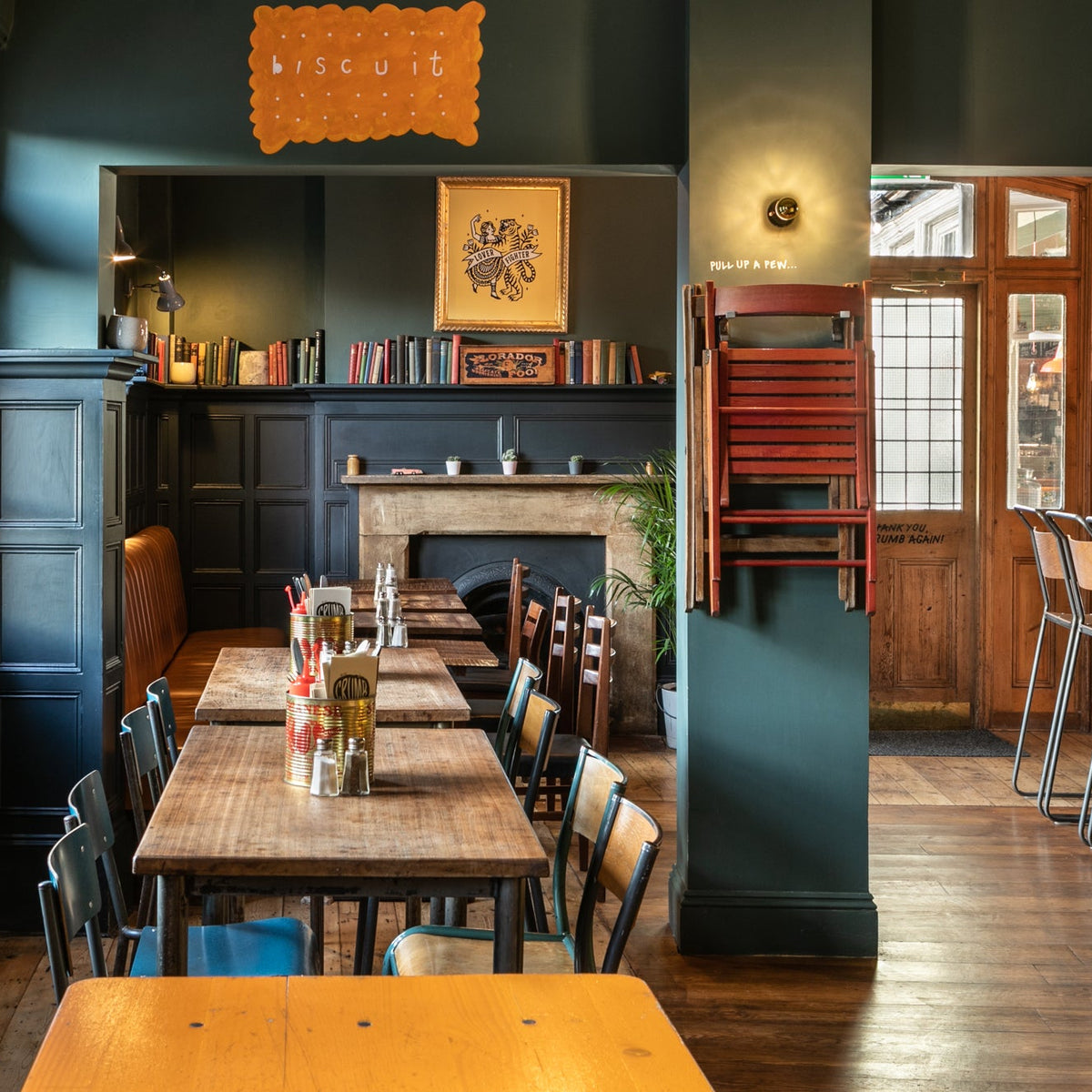 Long dining tables in front of a fireplace at The Last Crumb