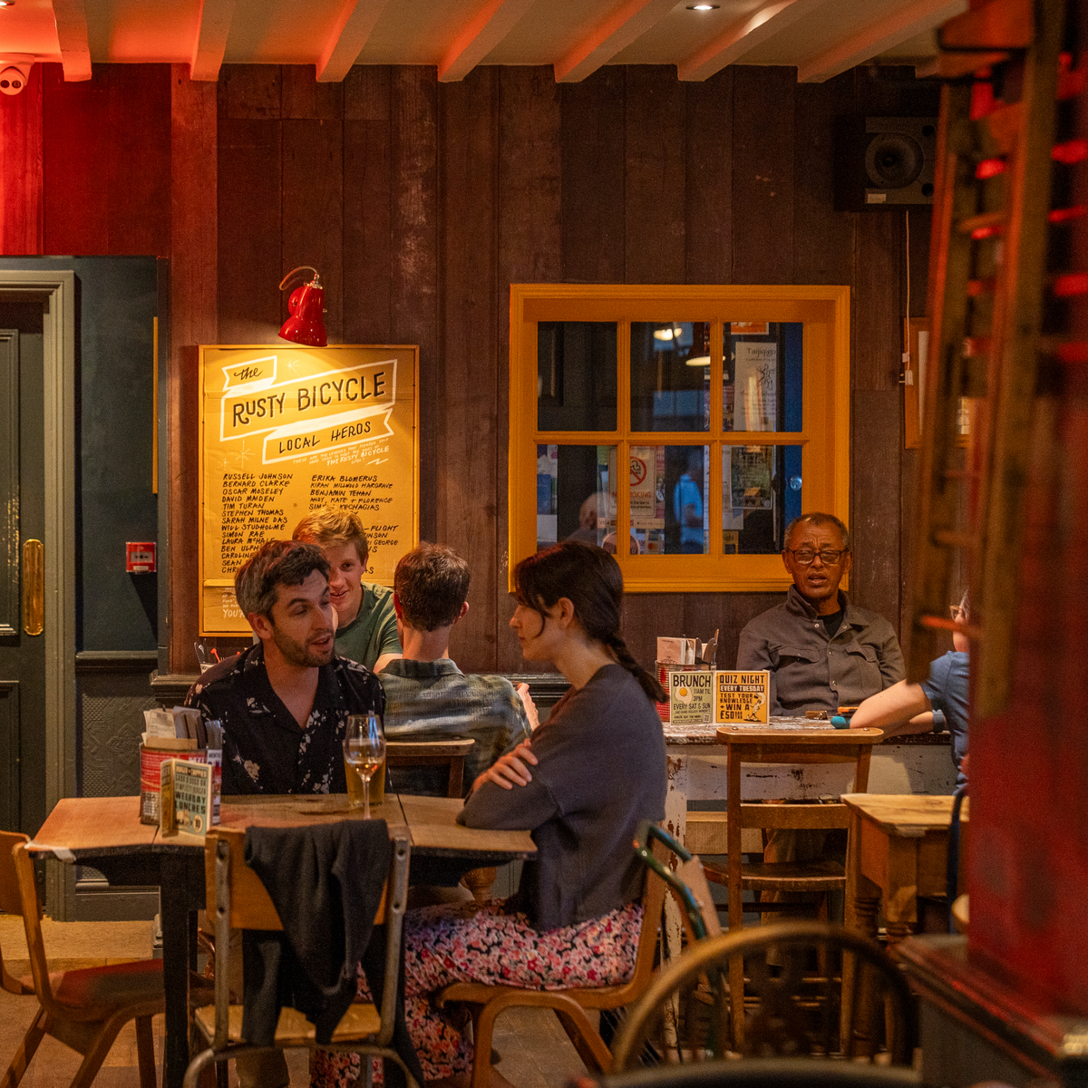 Customers chatting at tables inside The Rusty Bicycle