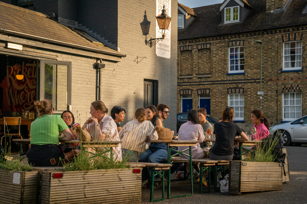 Customers at outdoor tables beside The Rickety Press