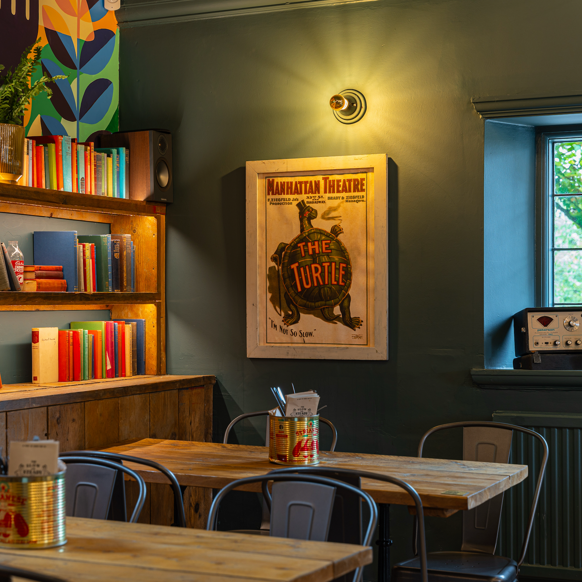 Corner table at The Slow & Steady with bookshelves and a vintage tortoise poster