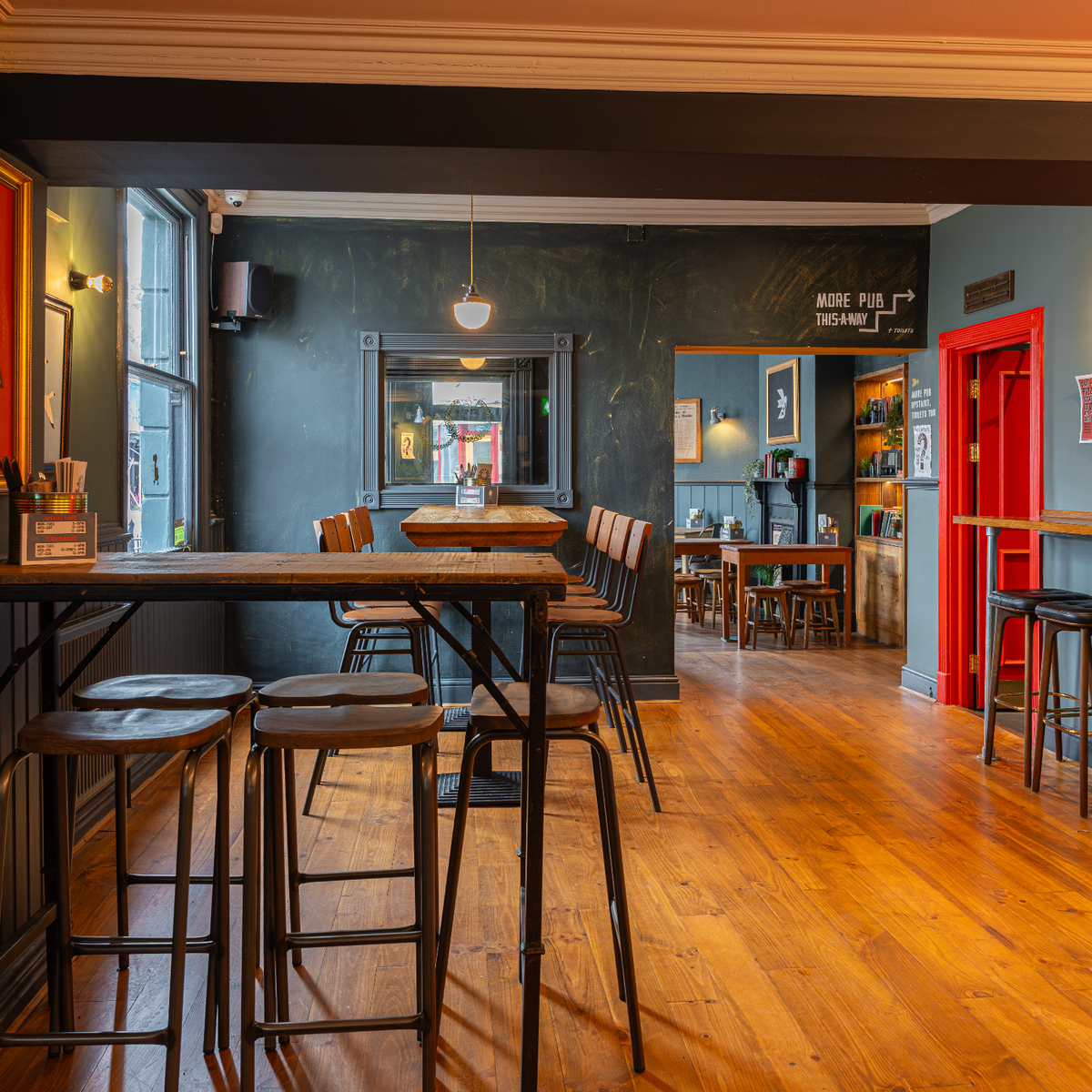 High tables and stools on wooden floors inside The Airs & Graces