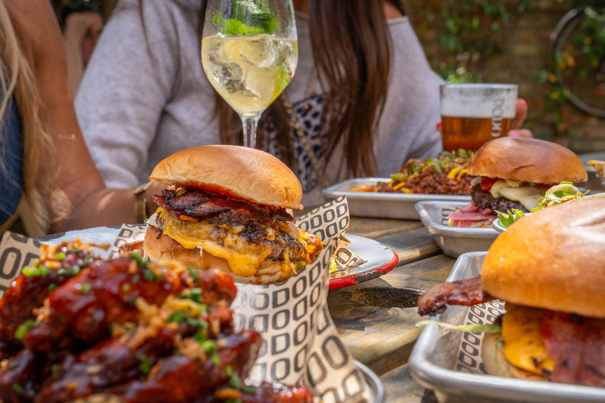 Burgers, wings and drinks shared on a pub table