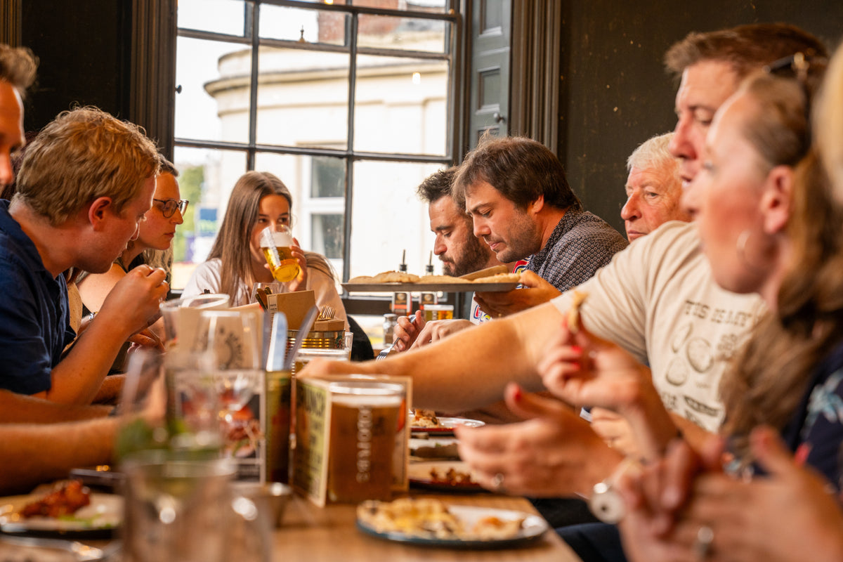 Friends sharing food and drinks around a pub table