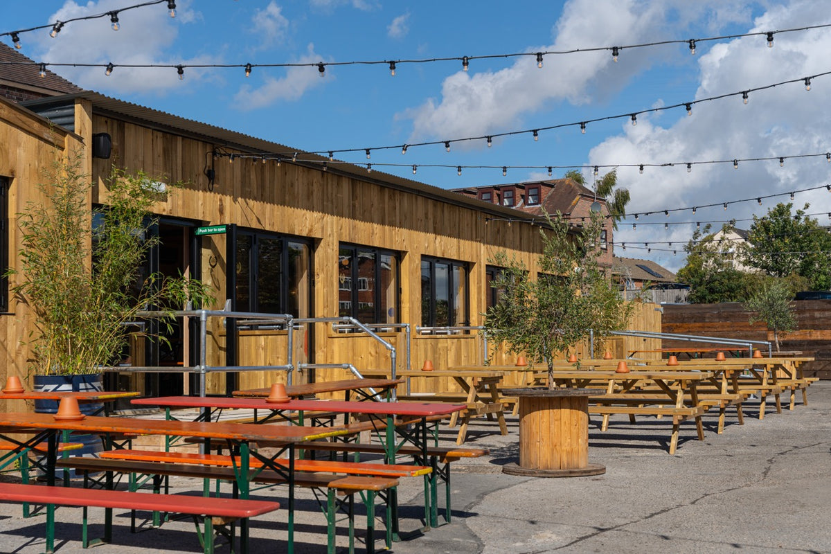 Large beer garden at The High Horse with picnic benches and festoon lights