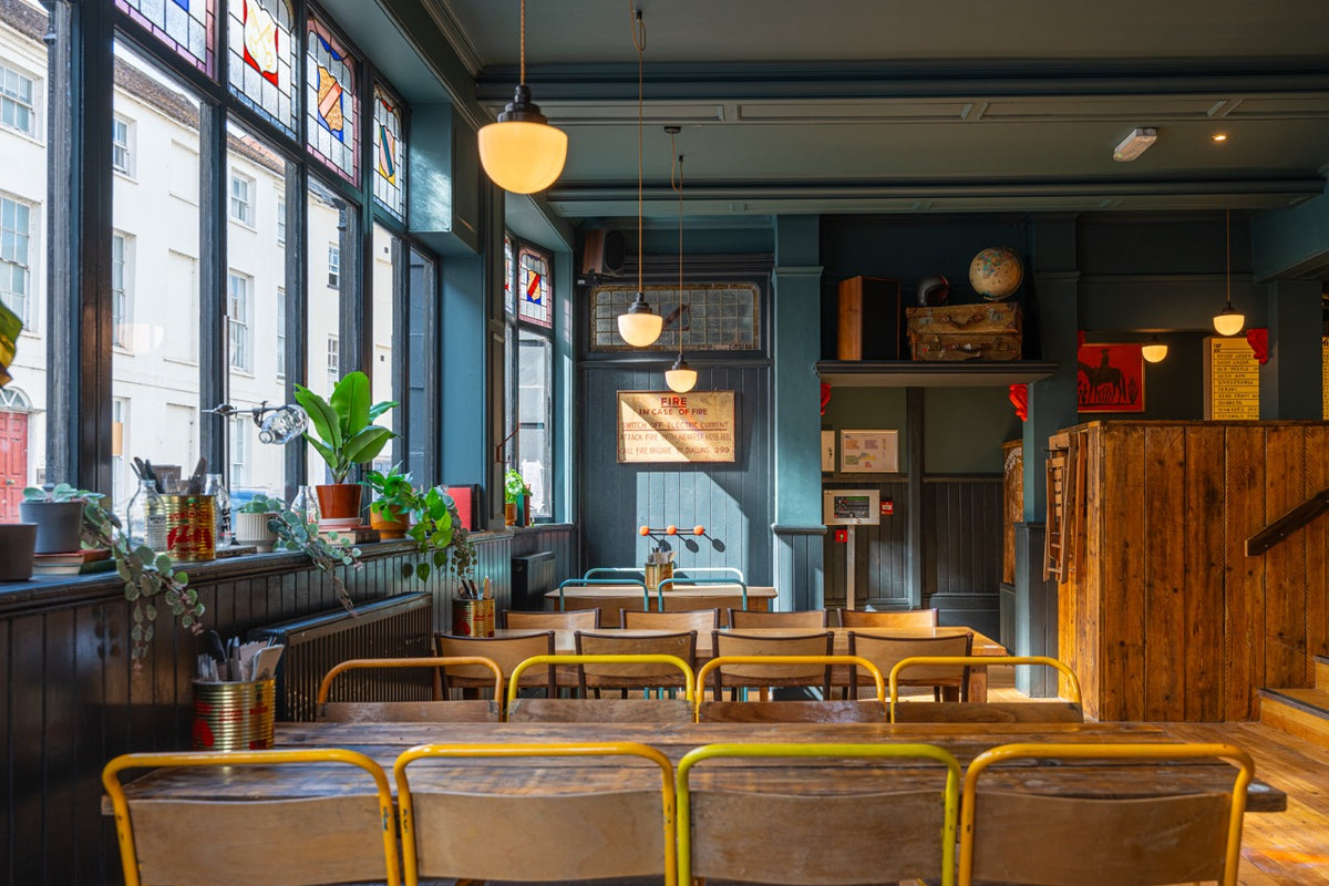 Dining room at The High Horse with stained glass windows and long tables