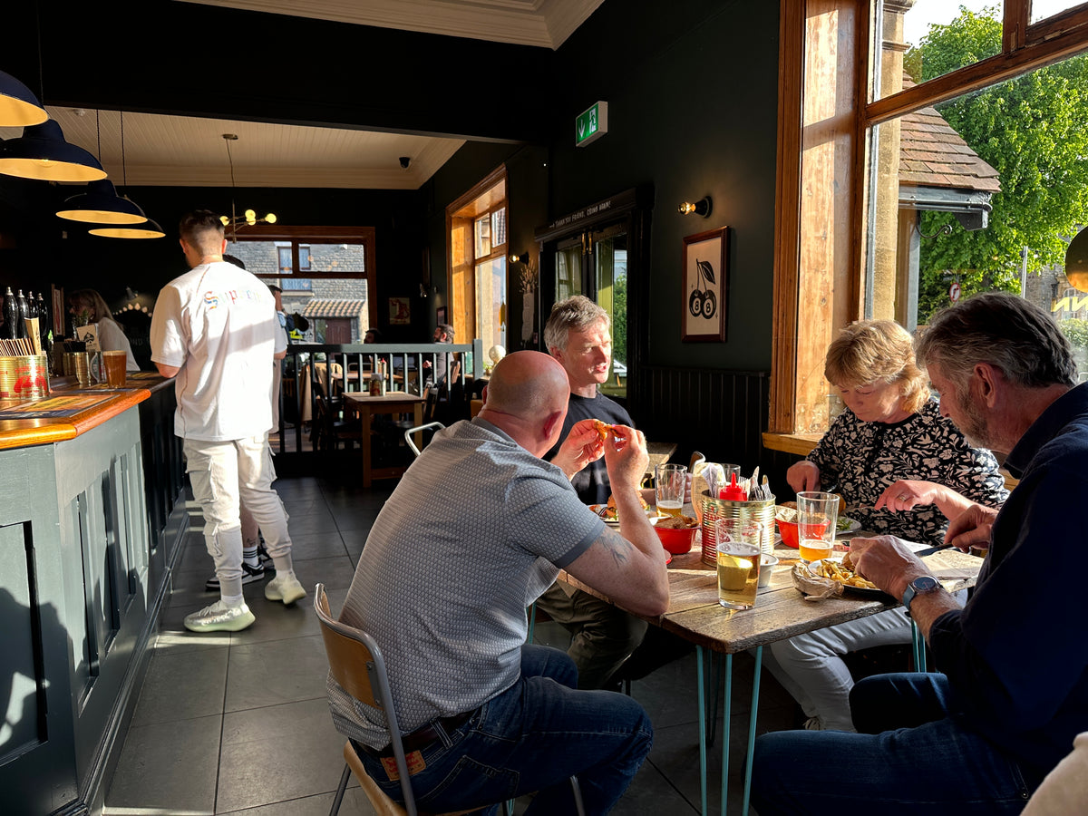 Customers eating at a table beside the bar