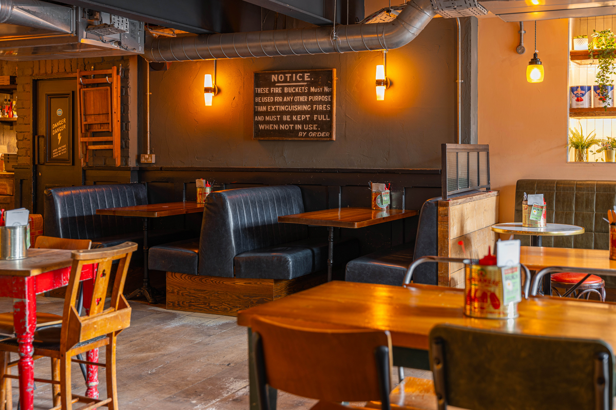Dining area at The Part & Parcel with leather booths and wooden tables