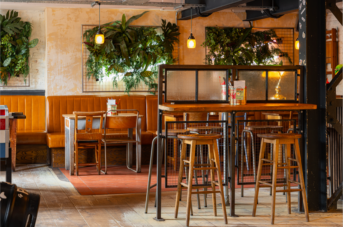 Seating area at The Part & Parcel with high tables, booths and hanging plants