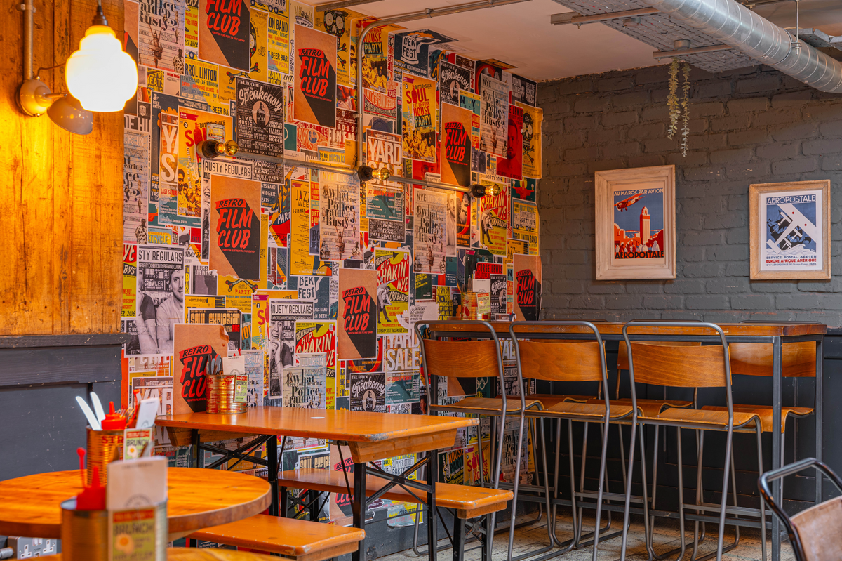 Seating area at The Part & Parcel with a colourful poster-covered wall