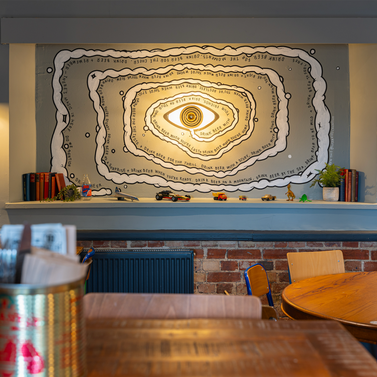 Seating at The Slow & Steady beneath a large painted eye mural