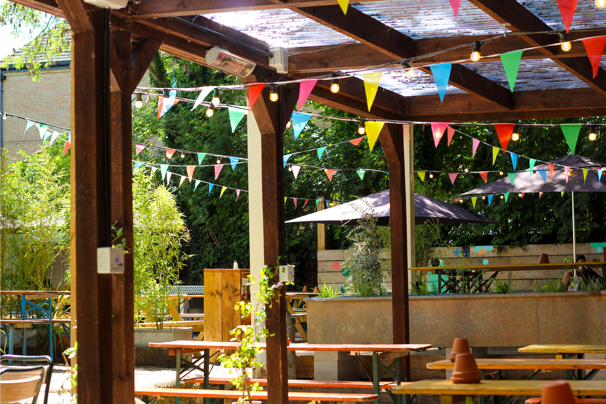 Covered garden at The Slow & Steady with wooden tables and bunting