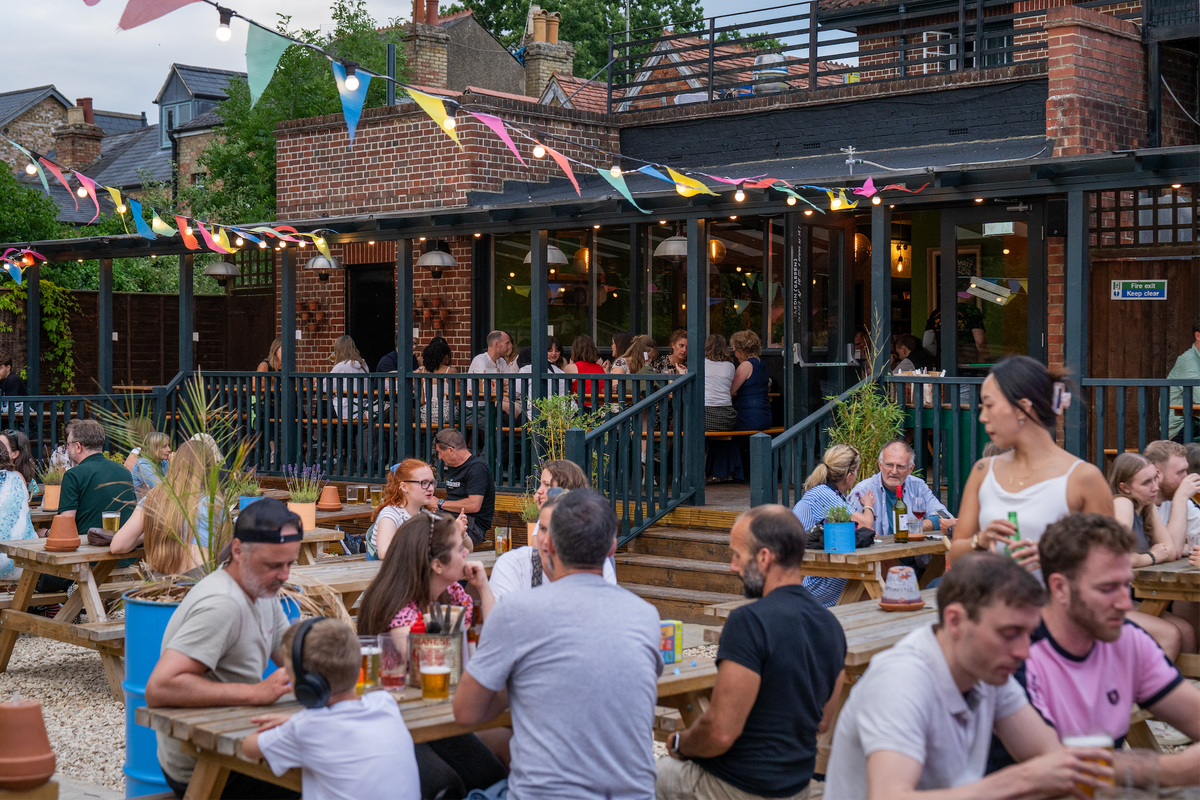 Busy beer garden at The Up In Arms with bunting and picnic tables